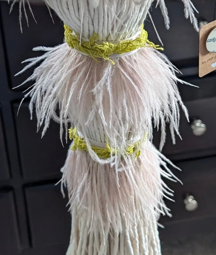 Lower part of the chandellier with soft pink feathers and green fabric details.
