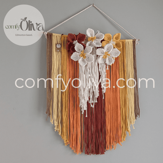 Decorative wall hanging with flowers and ribbons on a gray background, branded 'comfyOliva'.